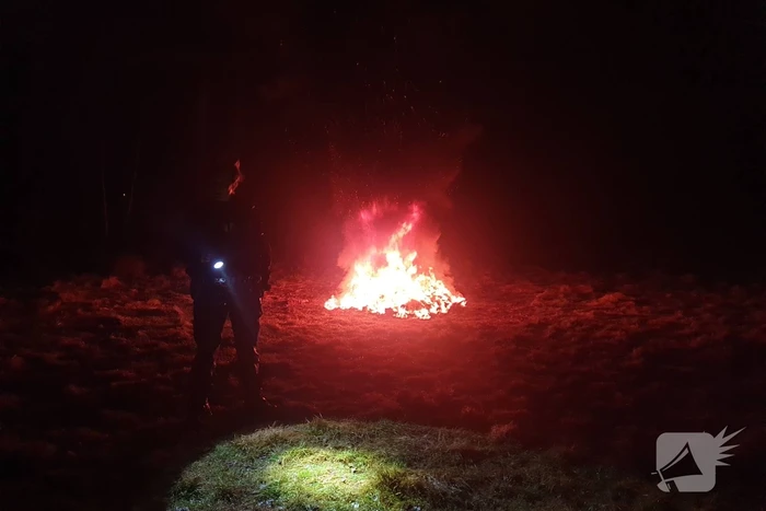 Brandweer blust brandende hoop afval