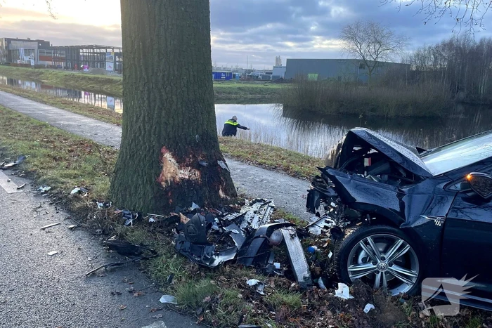 Auto ligt in de kreukels na flinke klap tegen boom