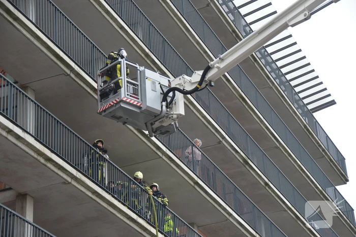 Zwarte rookwolk bij brand in flatwoning