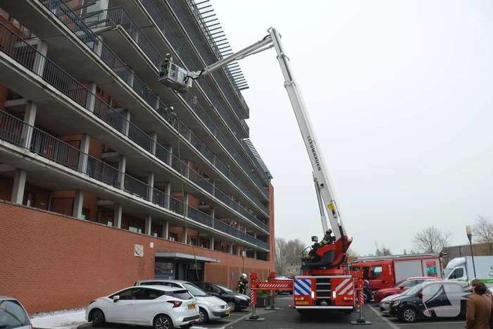 Zwarte rookwolk bij brand in flatwoning