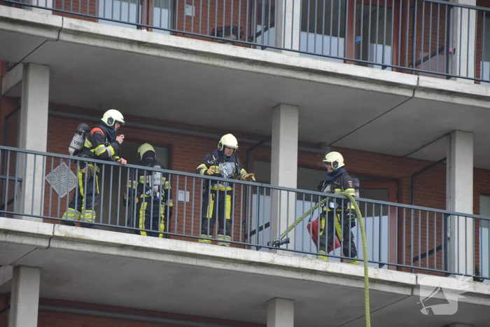Zwarte rookwolk bij brand in flatwoning