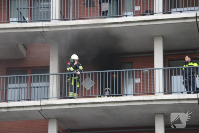 Zwarte rookwolk bij brand in flatwoning