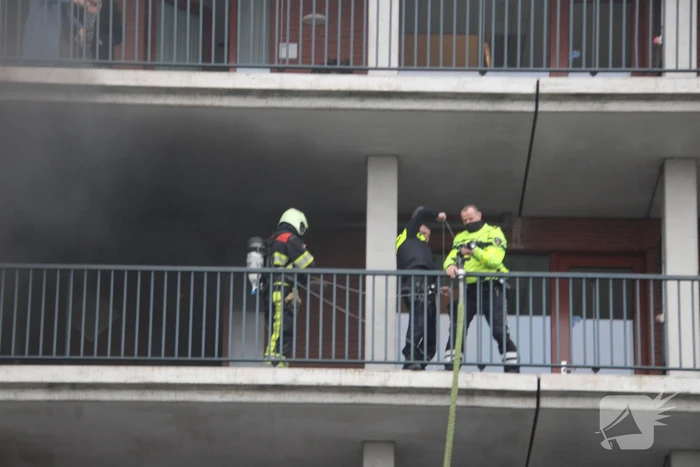 Zwarte rookwolk bij brand in flatwoning