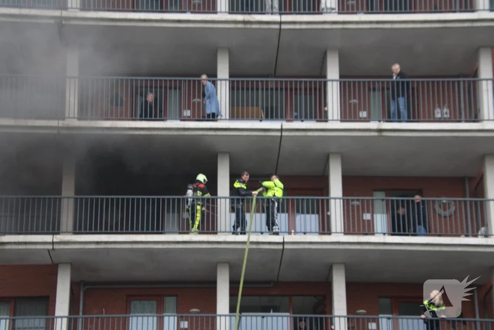 Zwarte rookwolk bij brand in flatwoning
