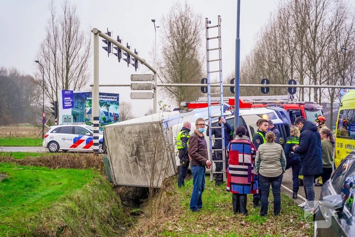 Bestelbus kantelt en belandt in sloot