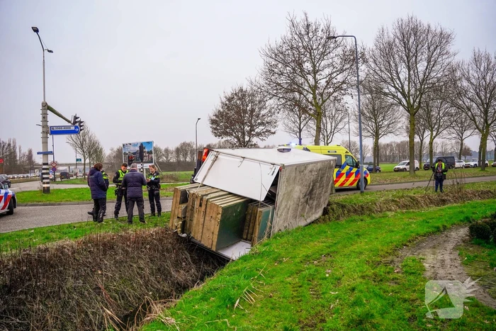 Bestelbus kantelt en belandt in sloot