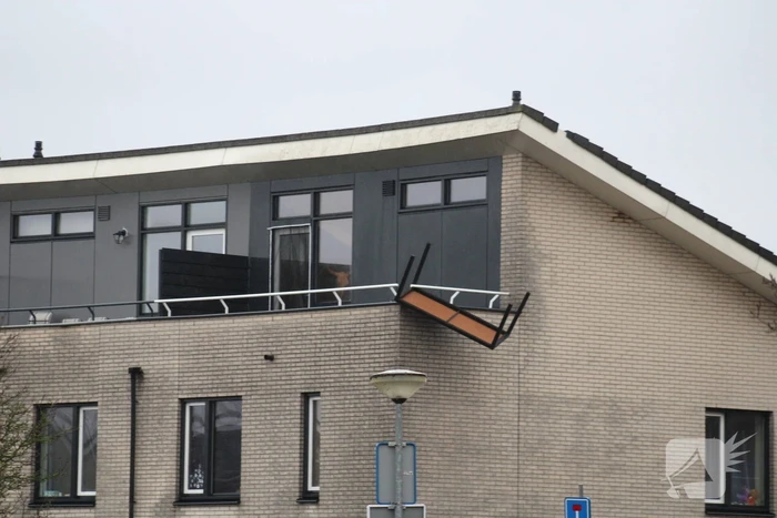Weggewaaide tafel hangt gevaarlijk over balkonrand