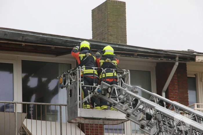 Brandweer verwijderd dakplaten en zet dakgoot vast