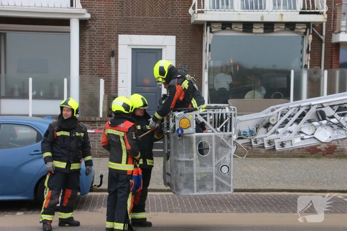 Brandweer verwijderd dakplaten en zet dakgoot vast