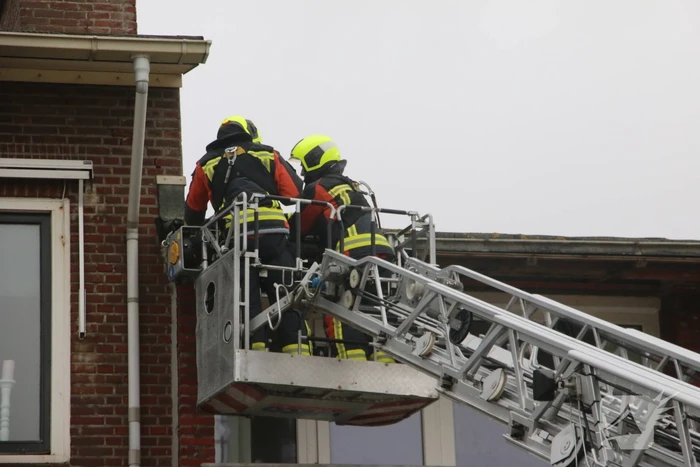 Brandweer verwijderd dakplaten en zet dakgoot vast