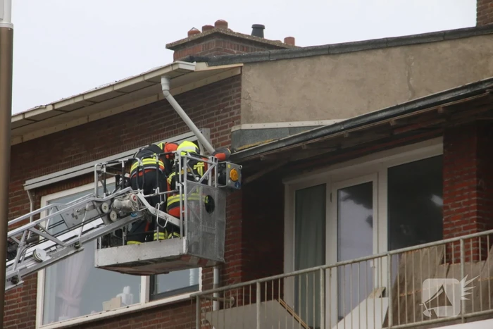 Brandweer verwijderd dakplaten en zet dakgoot vast
