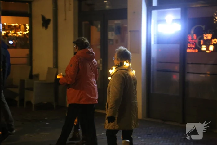Groep mensen loopt lichtjestocht tegen coronamaatregelen
