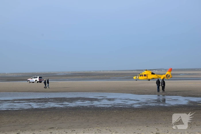 Personen ingesloten door water op zandbank