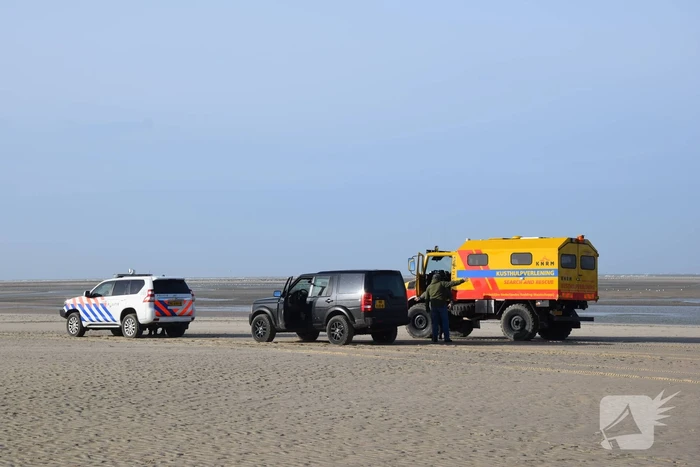 Personen ingesloten door water op zandbank