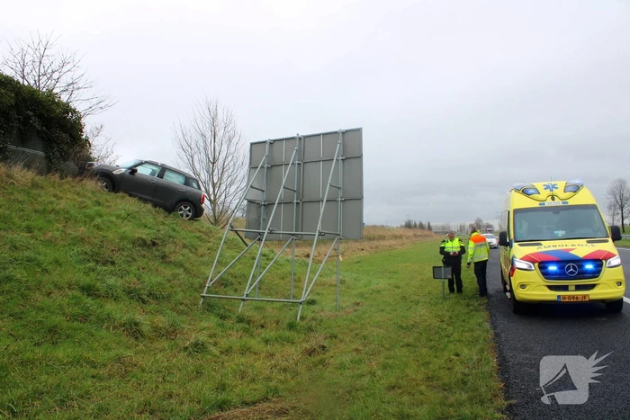 Automobilist raakt van de weg belandt boven op geluidswal