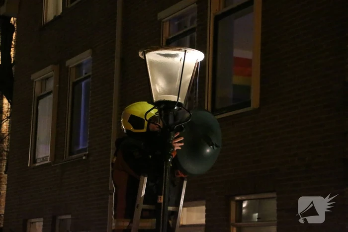 Brandweer haalt losse kap van lantaarnpaal