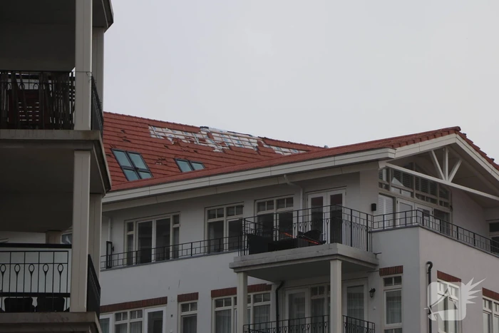 Dakpannen waaien van appartementencomplex