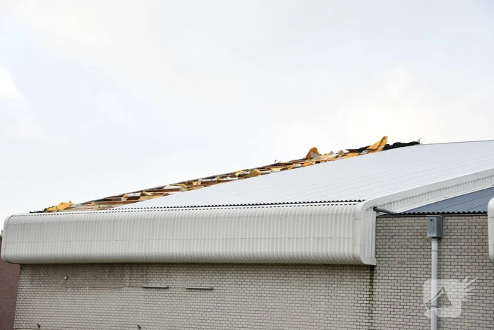 Dakbeplating van pand laat los door harde wind
