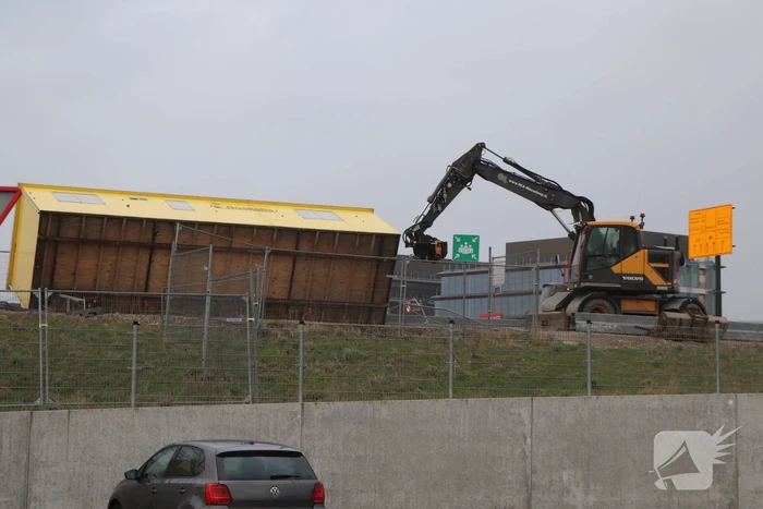 Bouwkeet waait om en belandt op wegdek