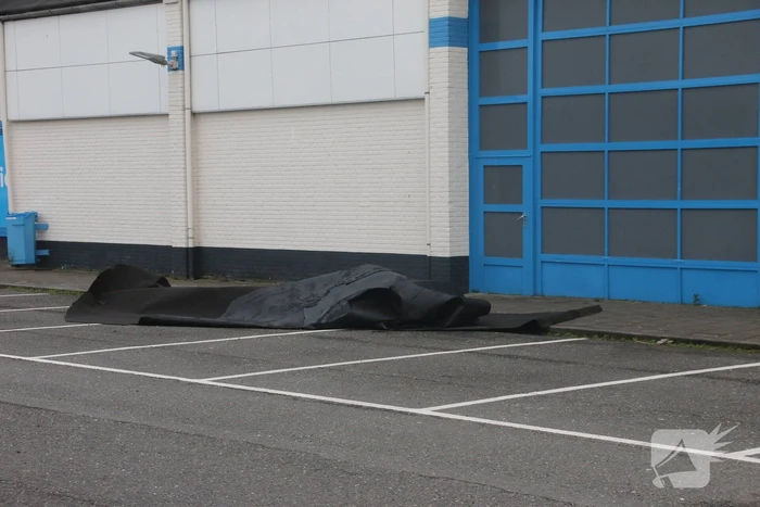 Dakbedekking waait van dak supermarkt