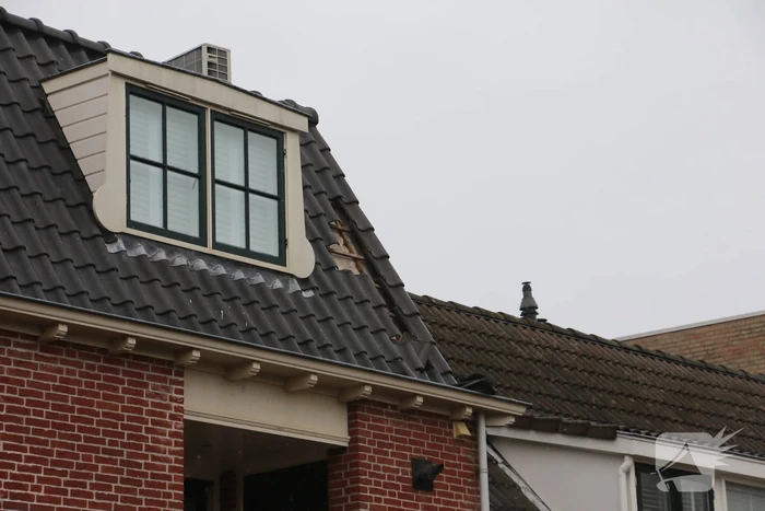 Brandweer verwijdert losse dakpannen van woning
