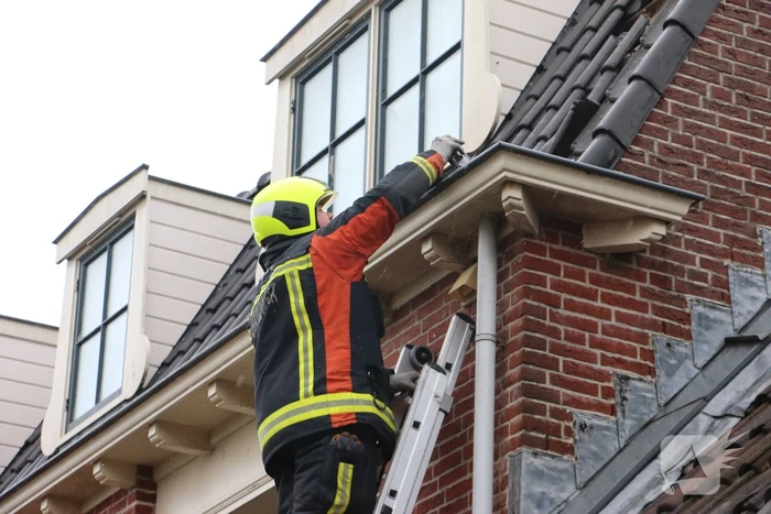 Brandweer verwijdert losse dakpannen van woning