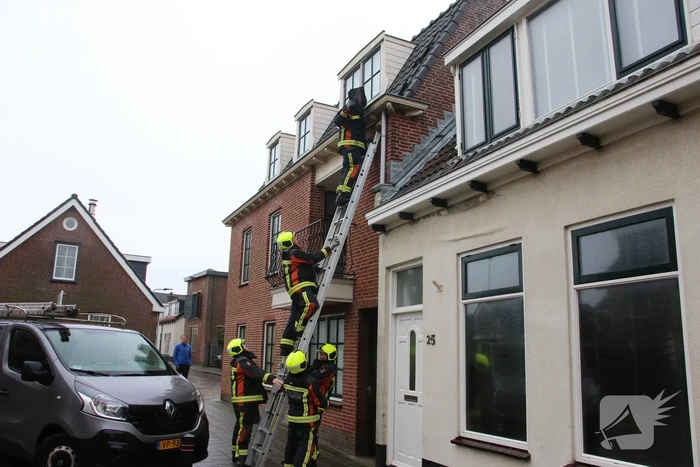Brandweer verwijdert losse dakpannen van woning
