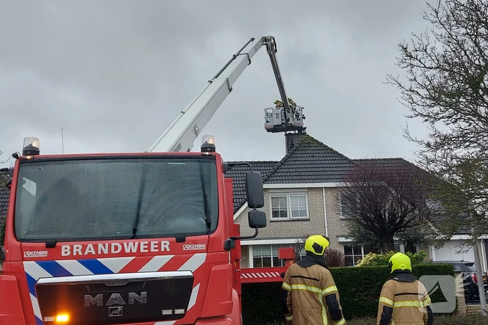 Brandweer verwijderd losse plaat op schoorsteen van woning