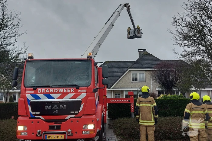 Brandweer verwijderd losse plaat op schoorsteen van woning