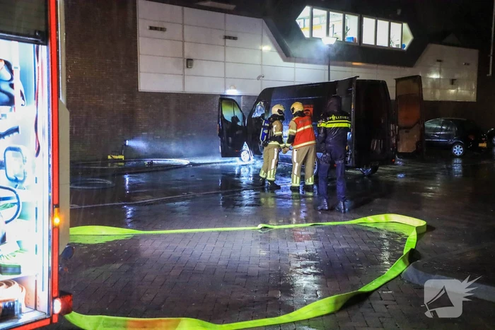 Bestelbus in brand tegen gevel Jumbo
