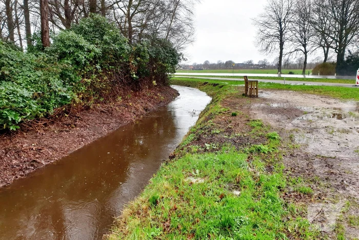 Wegdek en fietspad onder water door hevige regenval