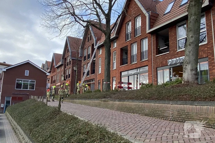 Voetpad afgesloten door losgeraakte dakpannen