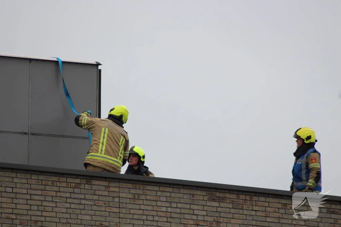 Platen ventilatiesysteem op dak van schoolgebouw waaien los