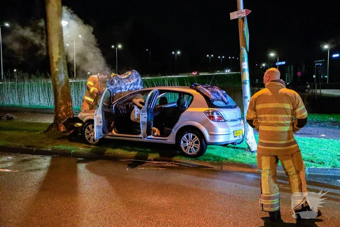 Auto vliegt in brand na botsing tegen boom