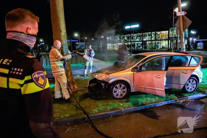 Auto vliegt in brand na botsing tegen boom