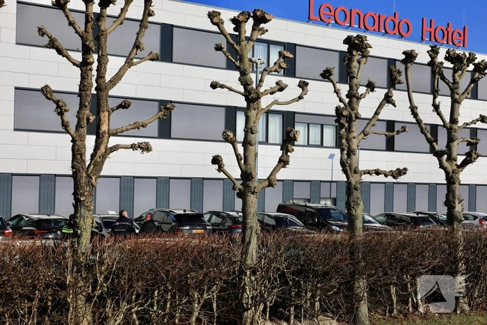 Wild-west-tafereel met automatisch wapen op parkeerplaats Leonardo Hotel