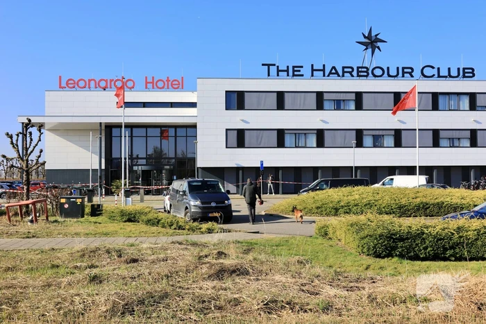 Wild-west-tafereel met automatisch wapen op parkeerplaats Leonardo Hotel