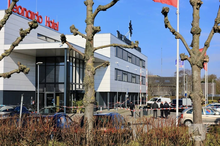 Wild-west-tafereel met automatisch wapen op parkeerplaats Leonardo Hotel