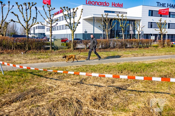 Wild-west-tafereel met automatisch wapen op parkeerplaats Leonardo Hotel