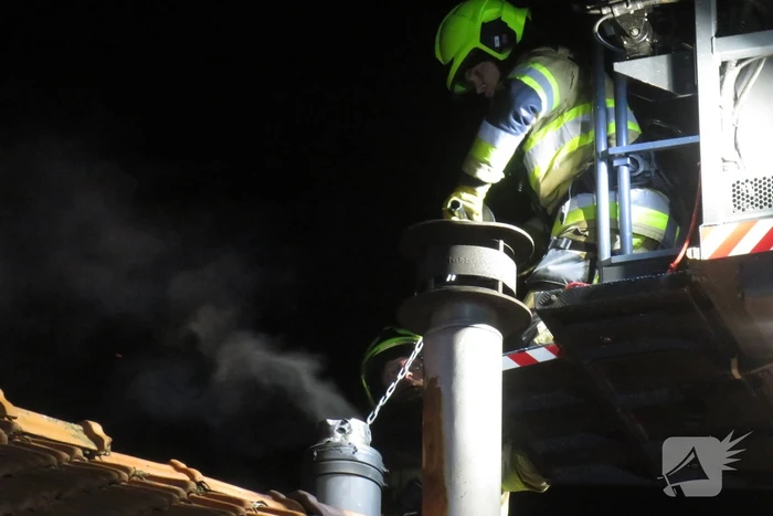 Vonken slaan uit schoorsteen van woning
