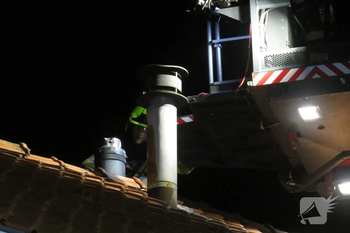 Vonken slaan uit schoorsteen van woning