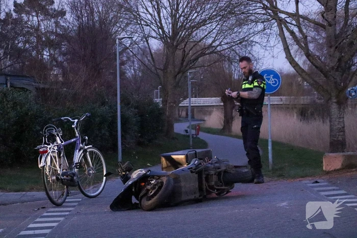 Fietser en bezorger op scooter in botsing