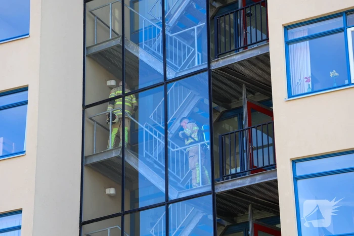 Brandweer blust brand op balkon