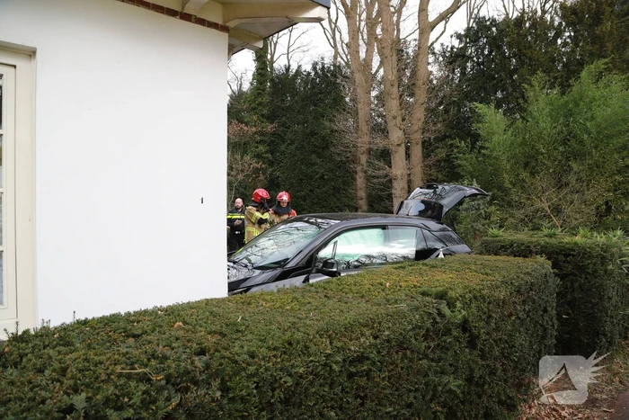 Auto crasht tegen woning