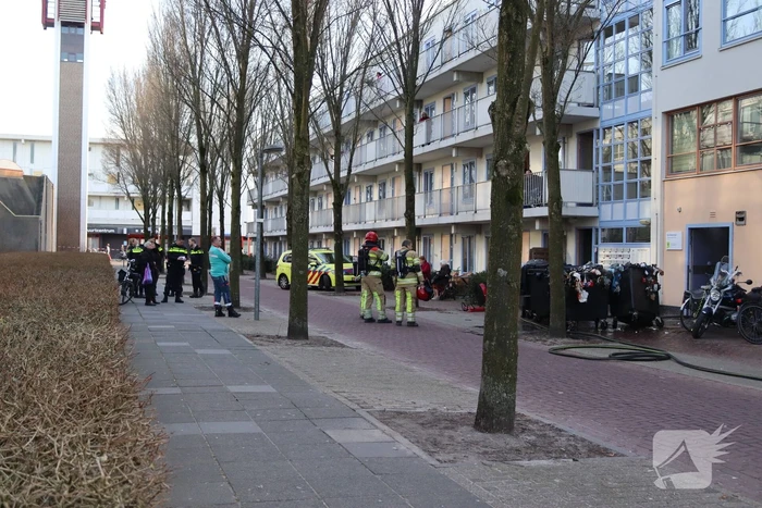 Containers vliegen in brand in flatgebouw