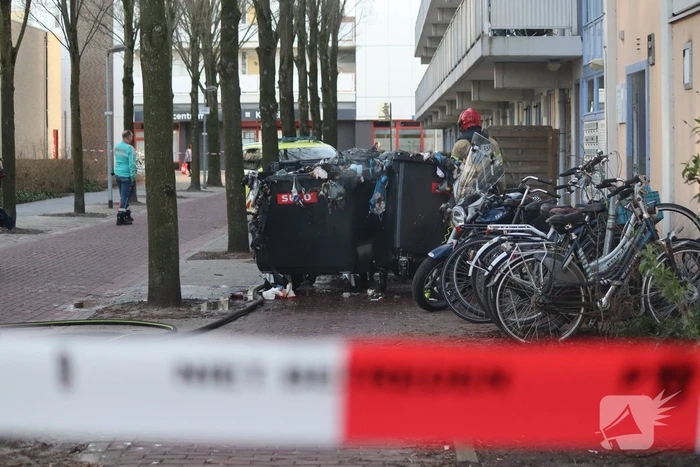 Containers vliegen in brand in flatgebouw