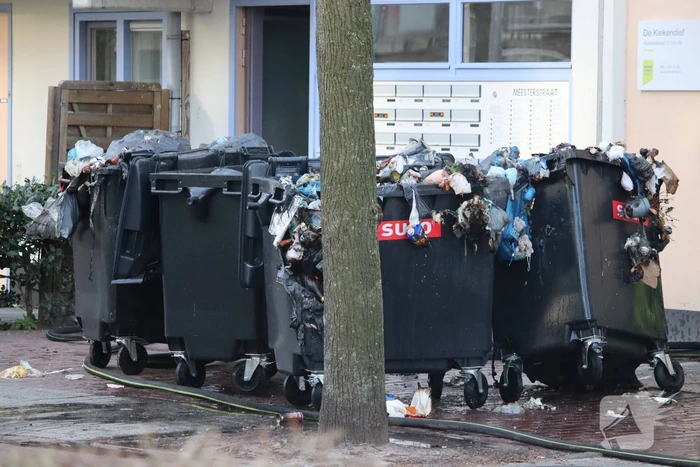 Containers vliegen in brand in flatgebouw