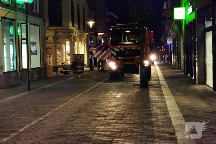 Brandweer blust brand in woning boven winkel