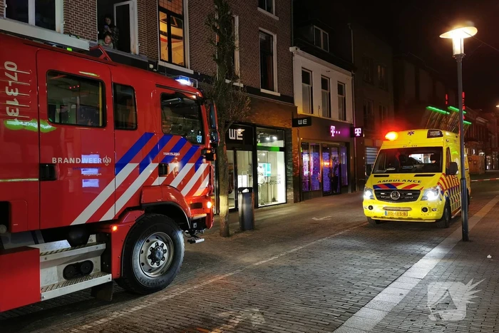 Brandweer blust brand in woning boven winkel