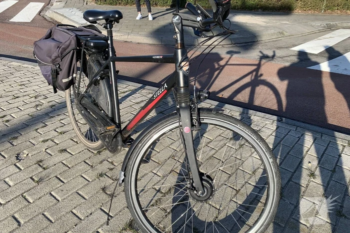 Auto schept e-biker op rotonde